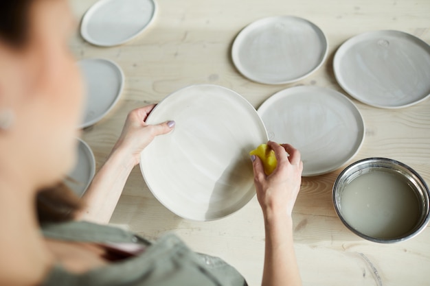 Ceramista femminile che fa i piatti