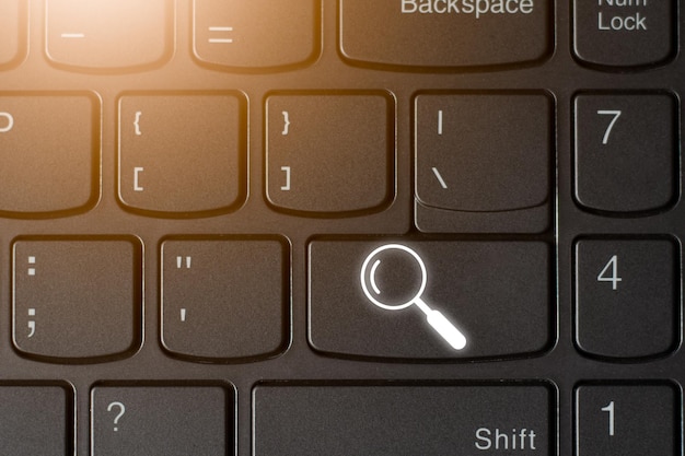 Cerca il simbolo dell'icona sulla tastiera del computer con la luce del computer che cerca lo spazio della copia del concetto di tecnologia online per il testo e il design individuali