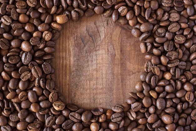 Cerchio fatto di chicchi di caffè su una superficie di legno da vicino