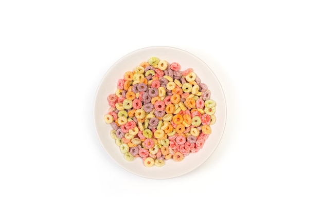 Cereali colorati al gusto di frutta in un piatto bianco su sfondo bianco in una vista dall'alto