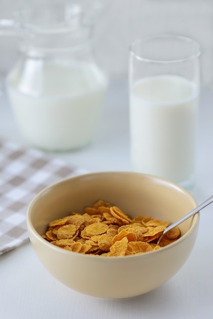 Cereali con latte su un tavolo bianco.