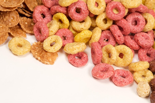 Cereali di mais sotto forma di anelli multicolori su sfondo bianco