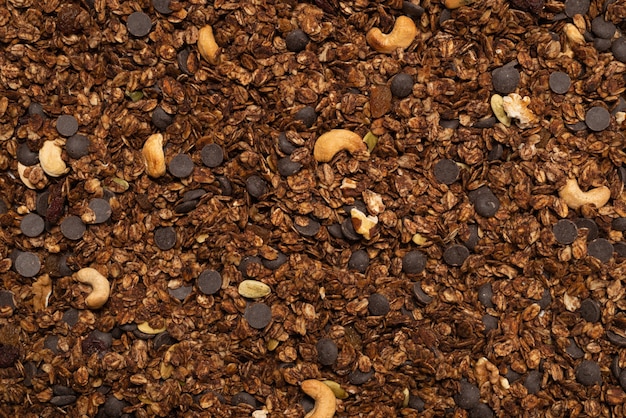 Cereali di muesli al cioccolato con sfondo di noci. Vista dall'alto.