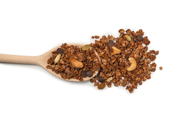 Cereali muesli al cioccolato con noci in un cucchiaio di legno. Isolato su sfondo bianco.