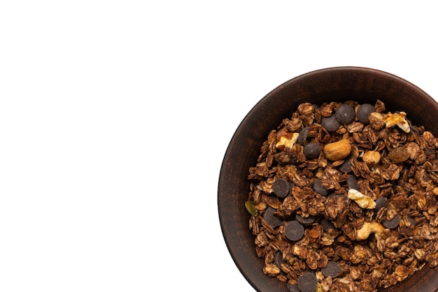 Cereali muesli al cioccolato con noci in uno sfondo di ciotola. Isolato su sfondo bianco.