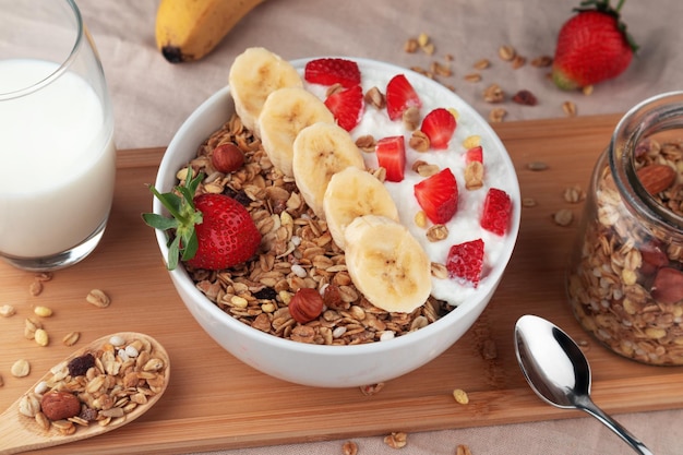Cereali muesli con latte di noci di fragola e banana in una ciotola su un tavolo Una sana colazione a base di cereali