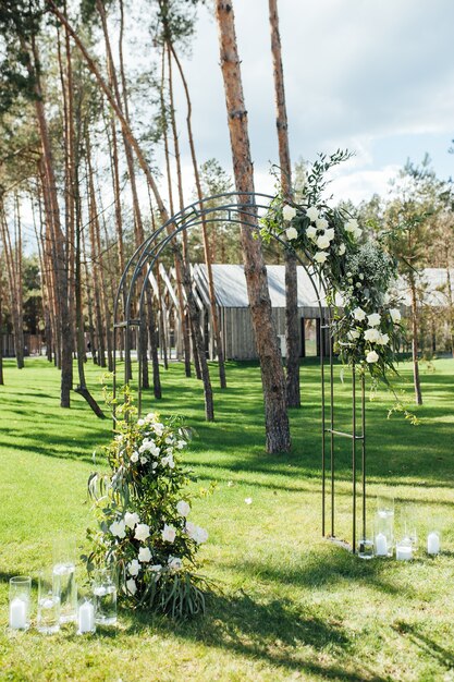 Cerimonia all'aperto molto bella matrimonio classico in arco di metallo foresta con fiori