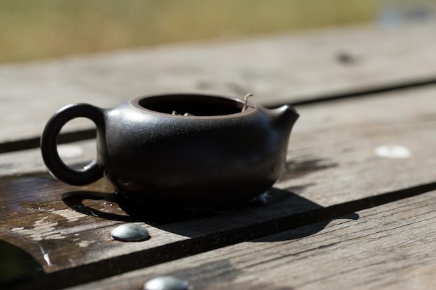 Cerimonia del tè cinese. Teiera in ceramica fatta di argilla e ciotole su fondo di legno.