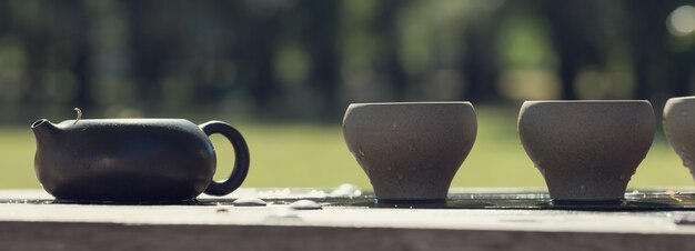 Cerimonia del tè cinese. Teiera in ceramica fatta di argilla e ciotole su uno sfondo di legno.