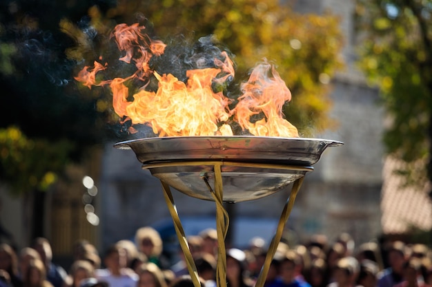 Cerimonia di accensione della fiamma Fiamma davanti alla folla sfocata