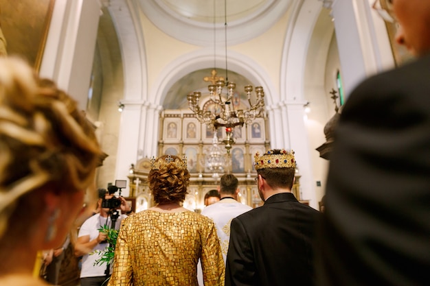 Cerimonia di matrimonio in una chiesa ortodossa, lo sposo, la sposa e il prete in abito talare, stanno nella
