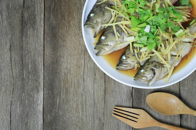 Cernia pesce o branzini Salsa di soia al vapore di frutti di mare tailandesi in piatto bianco