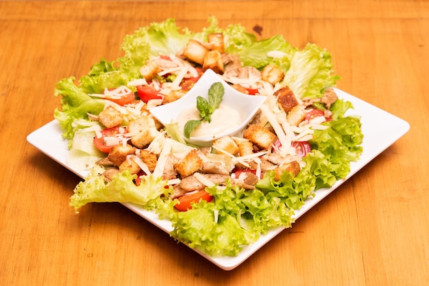 cesar salad su un piatto bianco su un tavolo di legno