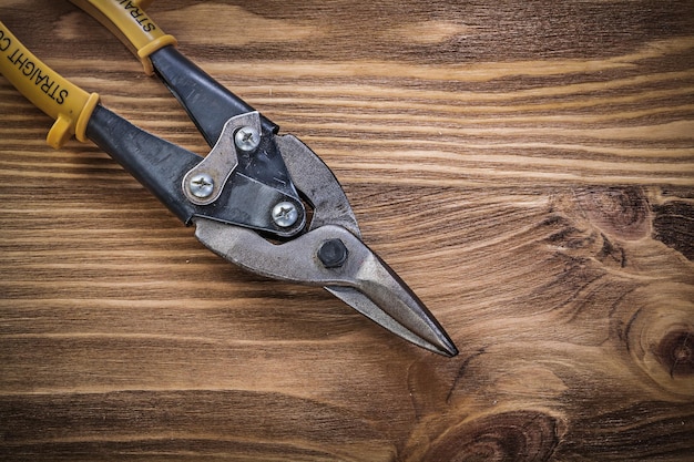 Cesoie di metallo taglienti su tavola di legno vintage vista dall'alto concetto di costruzione