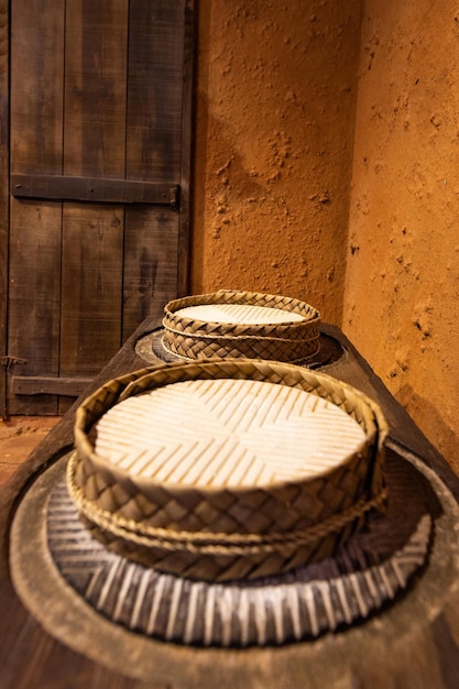 Cestini tradizionali in foglia di palma su un ripiano in legno con formaggi