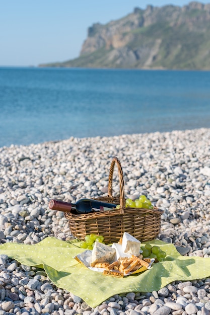 Cestino da picnic con vino, formaggio e uva