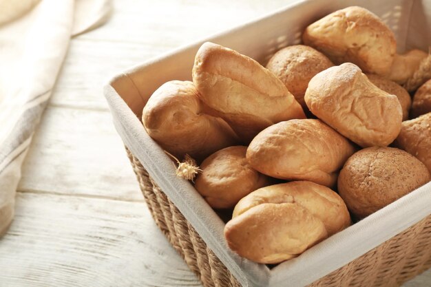 Cestino di vimini con diversi tipi di pane fresco sul tavolo