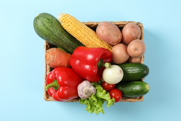 Cestino di vimini con le verdure sull'azzurro