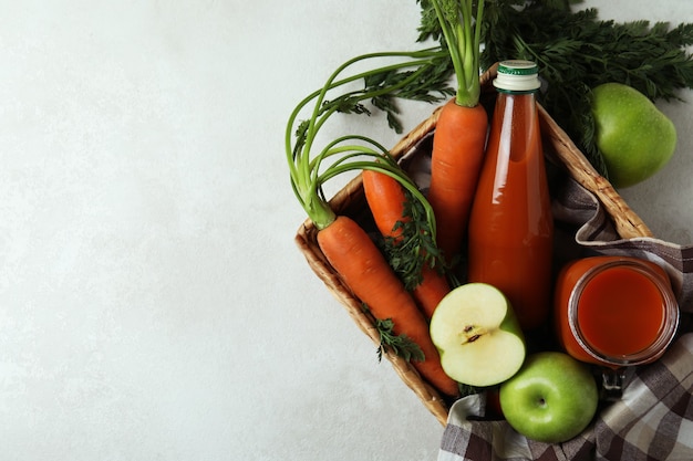 Cestino di vimini con mela - succo di carota e ingredienti