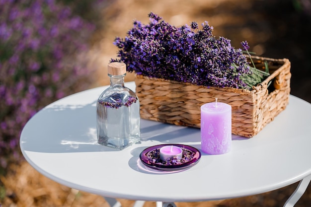 Cesto con bella lavanda nel campo di Provance con acqua di lavanda e candele Stagione della raccolta