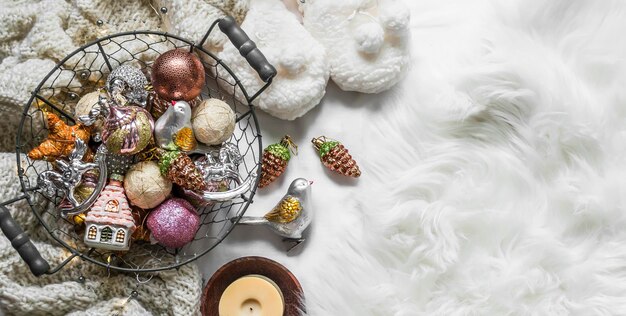 Cesto con decorazioni natalizie vintage su un soffice tappeto bianco vista dall'alto Striscione natalizio con spazio per la copia