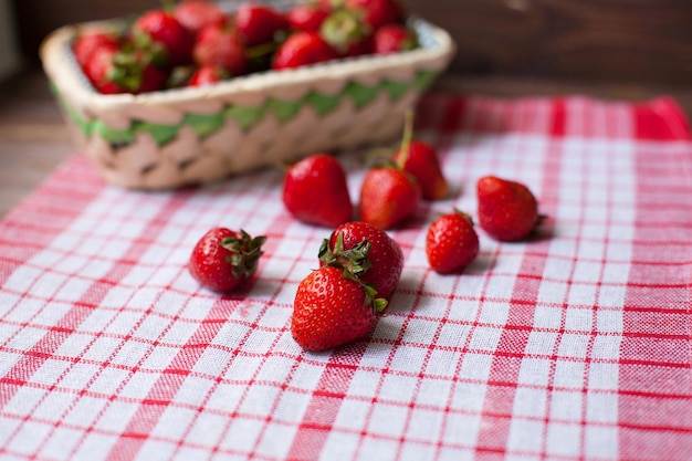 Cesto con fragole fresche deliziose sulla tovaglia