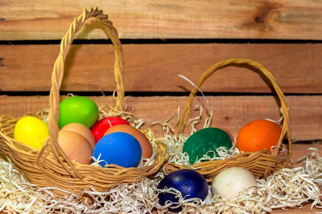 cesto di uova di Pasqua colorate con fondo in legno rustico