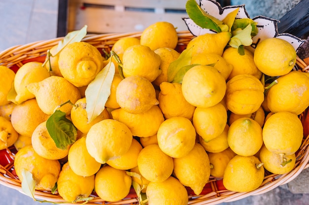 Cesto di vimini pieno di limoni sulla via italiana di Corniglia