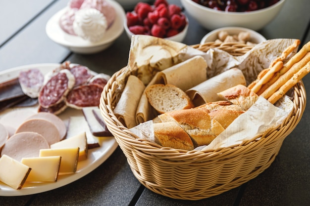 Cesto pieno di pane francese sul tavolo con snack