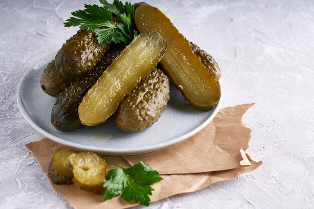 Cetrioli sottaceto con erbe e cipolle in un piatto sul tavolo Probiotici cibo