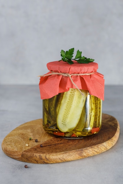 Cetriolo conservato fermentato in barattolo di vetro sul soggiorno di legno. Il concetto di cibo in scatola.