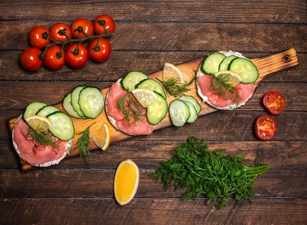 Cetriolo di salmone e panino di segale con formaggio cremoso sulla vista superiore del fondo di legno