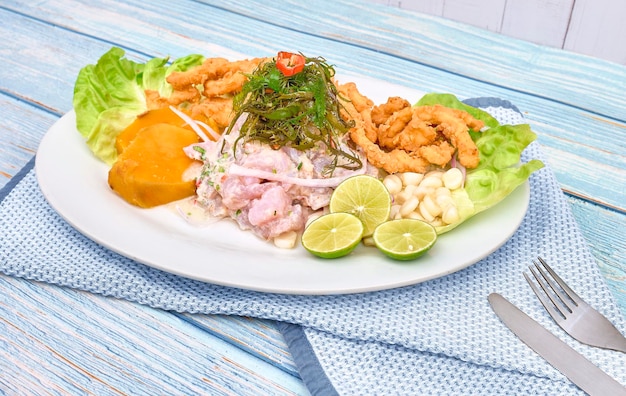 Ceviche tradizionale peruviano con pesce, pancake di mais, patate dolci e succo piccante Ceviche y chicharron