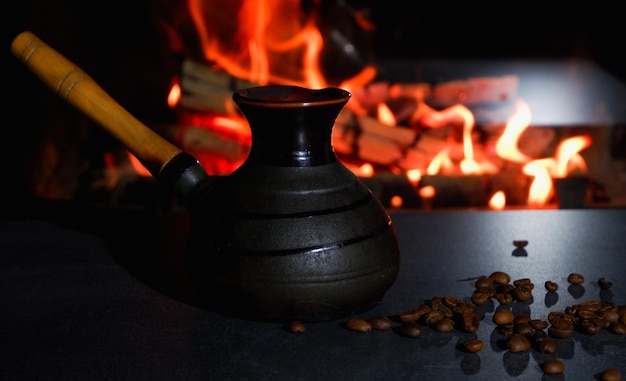 Cezve e tazze di caffè con chicchi di caffè sullo sfondo di un fuoco ardente caffè turco