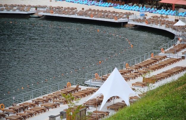 Chaise longue in legno nella zona termale sulla riva del lago