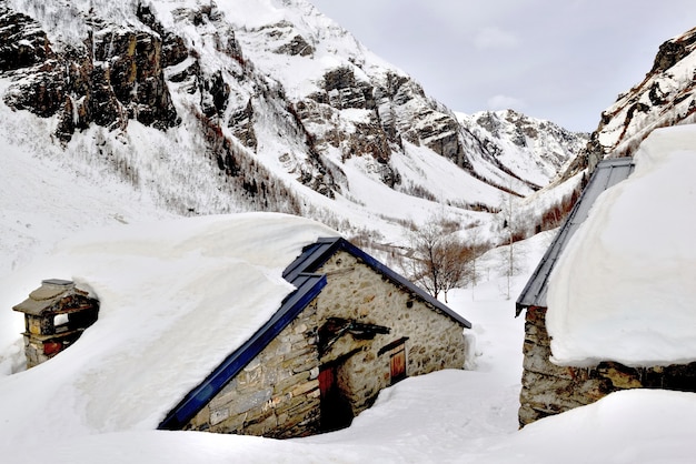 Chalet in un villaggio sepolto nella neve in montagna alpina in inverno