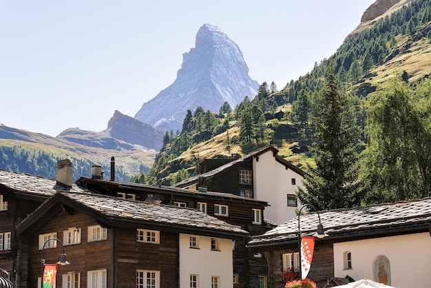 Chalet svizzeri tradizionali a Zermatt con vetta del Cervino con bandiere, Svizzera in estate.