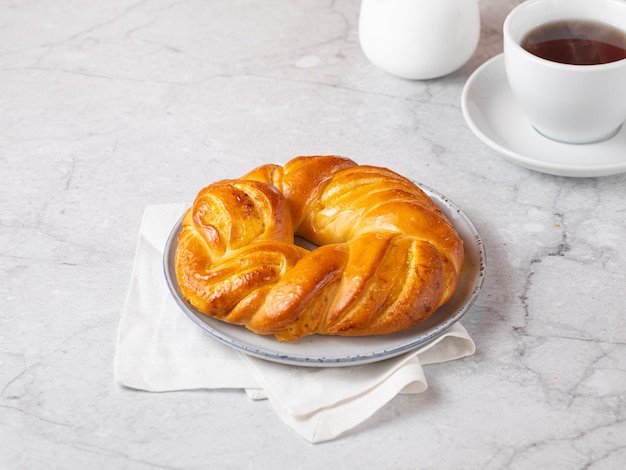 Challah rotondo fatto in casa su sfondo di marmo chiaro Tradizionale pasticceria ebraica appena sfornata