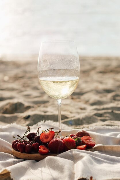 Champagne con un vassoio di frutta fragole e ciliegie su un picnic