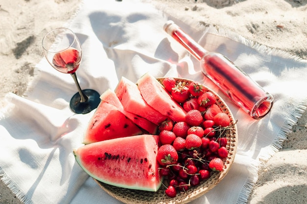 Champagne con un vassoio di frutta fragole e ciliegie su un picnic