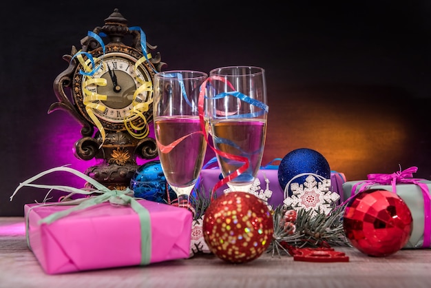 Champagne in bicchieri sul tavolo di legno con regali di Natale colorati