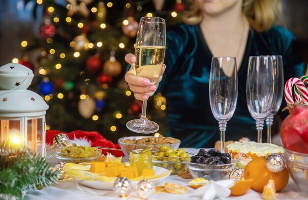 Champagne in mano su un albero di Natale da solo