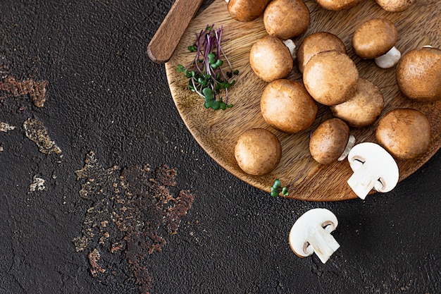 Champignon fresco su un piatto di legno