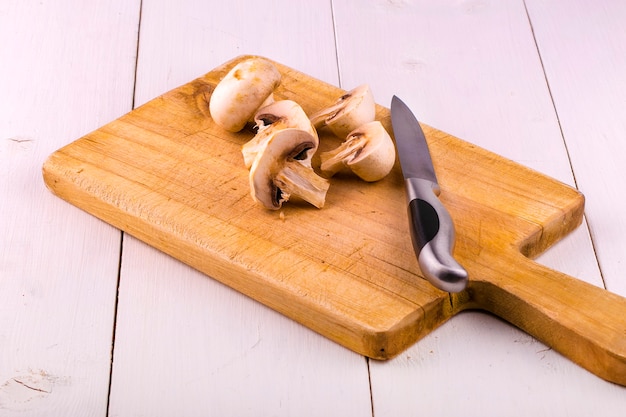 Champignons su una tavola di legno e un coltello da tavola.