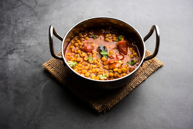 Chana Dal fry cotto o Split Bengal Gram tadka servito in una ciotola o padella, fuoco selettivo