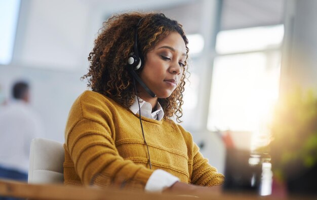 Chat di assistente virtuale o ragazza che digita la consulenza di call center online presso l'help desk del servizio clienti Consulente di computer Crm o donna birazziale nel telemarketing o agenzia di telecomunicazioni in ufficio