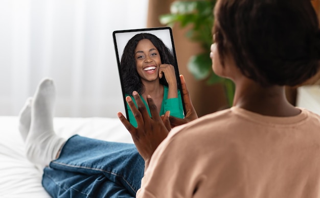 Chat virtuale donna nera che utilizza tablet digitale per una conferenza web con un amico
