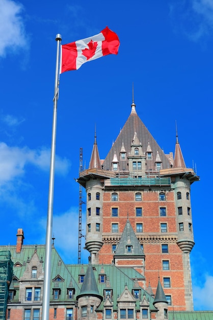 Chateau Frontenac nel giorno con nuvole e cielo blu a Quebec City con bandiera nazionale