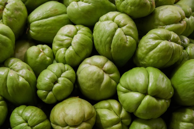 Chayote verdi posti su uno scaffale per la vendita all'interno di un mercato