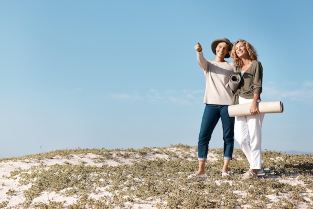 Che dire di lì Colpo a figura intera di due attraenti donna matura in piedi con la loro sulla spiaggia